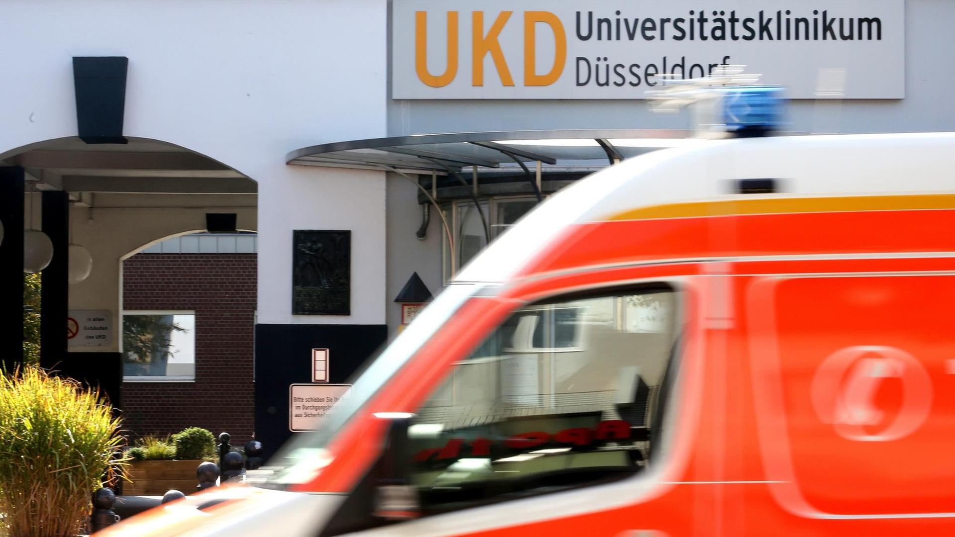 Am Haupteingang zum Universitätsklinikum Düsseldorf fährt ein Krankenwagen vorbei Am Haupteingang zum Universitätsklinikum Düsseldorf fährt ein Krankenwagen vorbei