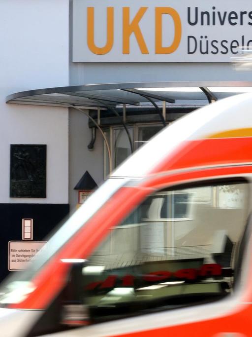 Am Haupteingang zum Universitätsklinikum Düsseldorf fährt ein Krankenwagen vorbei