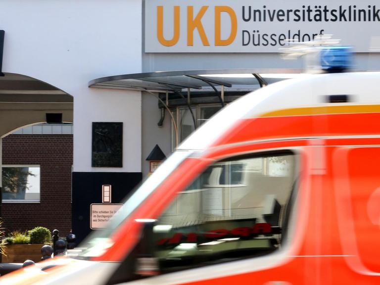 Am Haupteingang zum Universitätsklinikum Düsseldorf fährt ein Krankenwagen vorbei