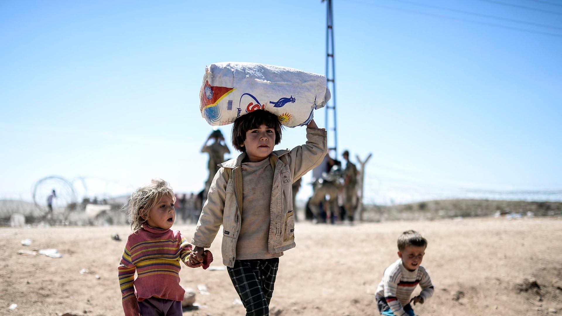 Syrische Kurden überqueren am 20. September 2014 die Grenze nahe der Stadt Suruc die Grenze von Syrien zur Türkei. Syrische Kurden überqueren am 20. September 2014 die Grenze nahe der Stadt Suruc die Grenze von Syrien zur Türkei.