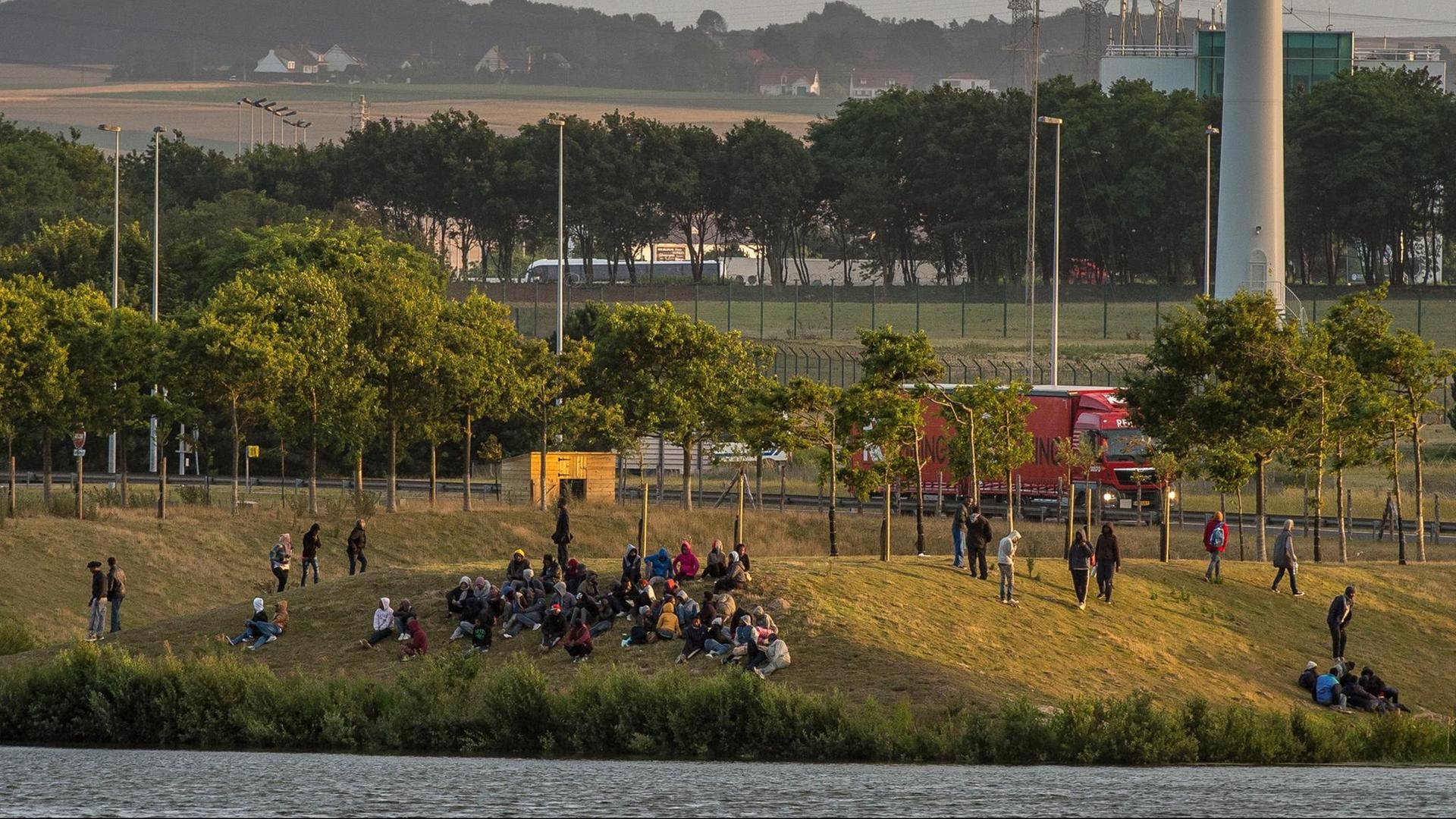 Flüchtlinge sitzen in der Nähe der Autobahn A16 bei Calais und warten auf ihre Chance, über den Eurotunnel nach Großbritannien zu gelangen. Flüchtlinge sitzen in der Nähe der Autobahn A16 bei Calais und warten auf ihre Chance, über den Eurotunnel nach Großbritannien zu gelangen.