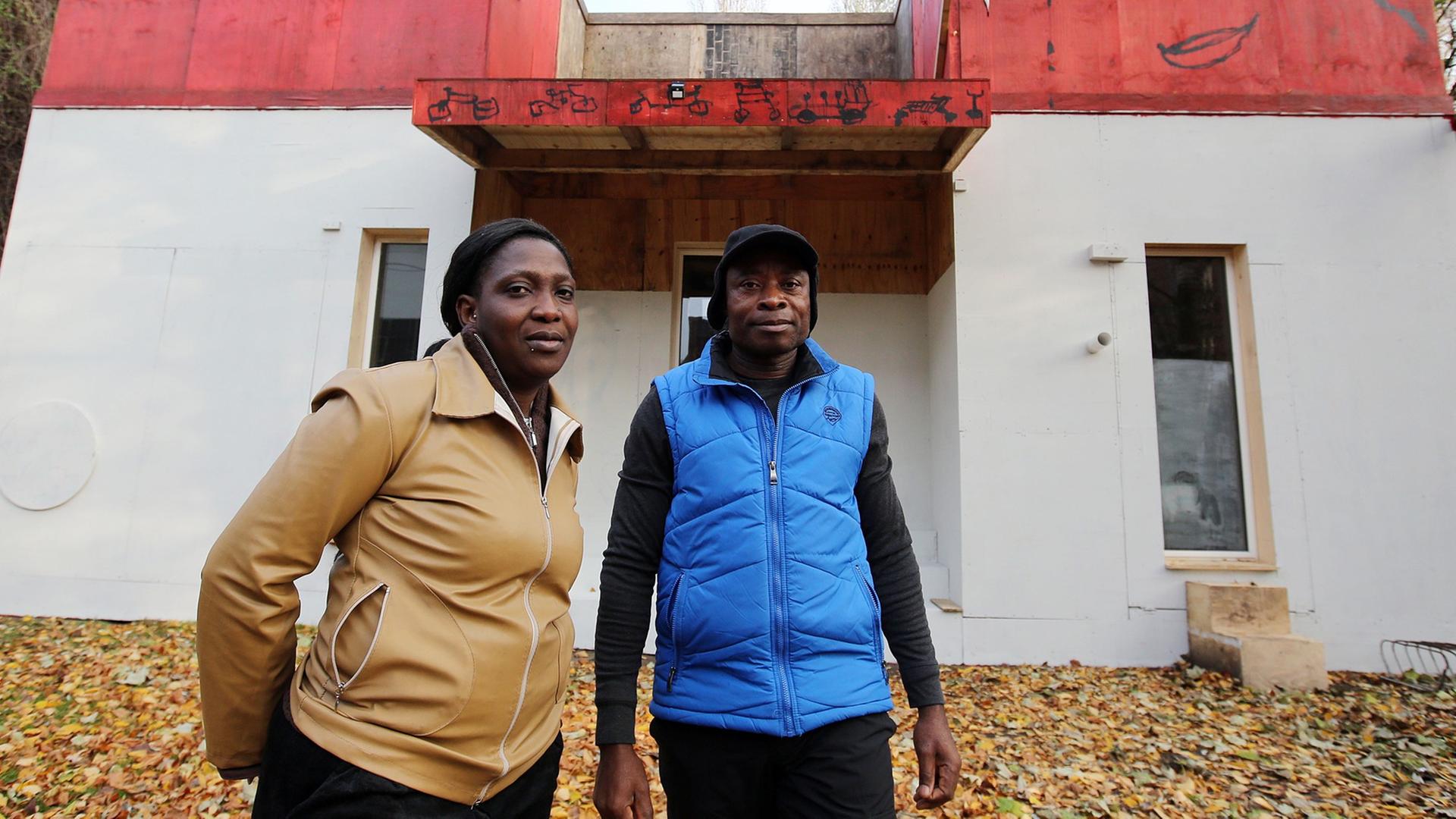 Der Sprecher der Lampedusa-Gruppe, Asuquo Udo, und Esther Olaide Olokodena, Mitglied der Gruppe, vor dem Kunstprojekt und Flüchtlingsquartier "Ecofavela" auf Kampnagel in Hamburg. Der Sprecher der Lampedusa-Gruppe, Asuquo Udo, und Esther Olaide Olokodena, Mitglied der Gruppe, vor dem Kunstprojekt und Flüchtlingsquartier "Ecofavela" auf Kampnagel in Hamburg.