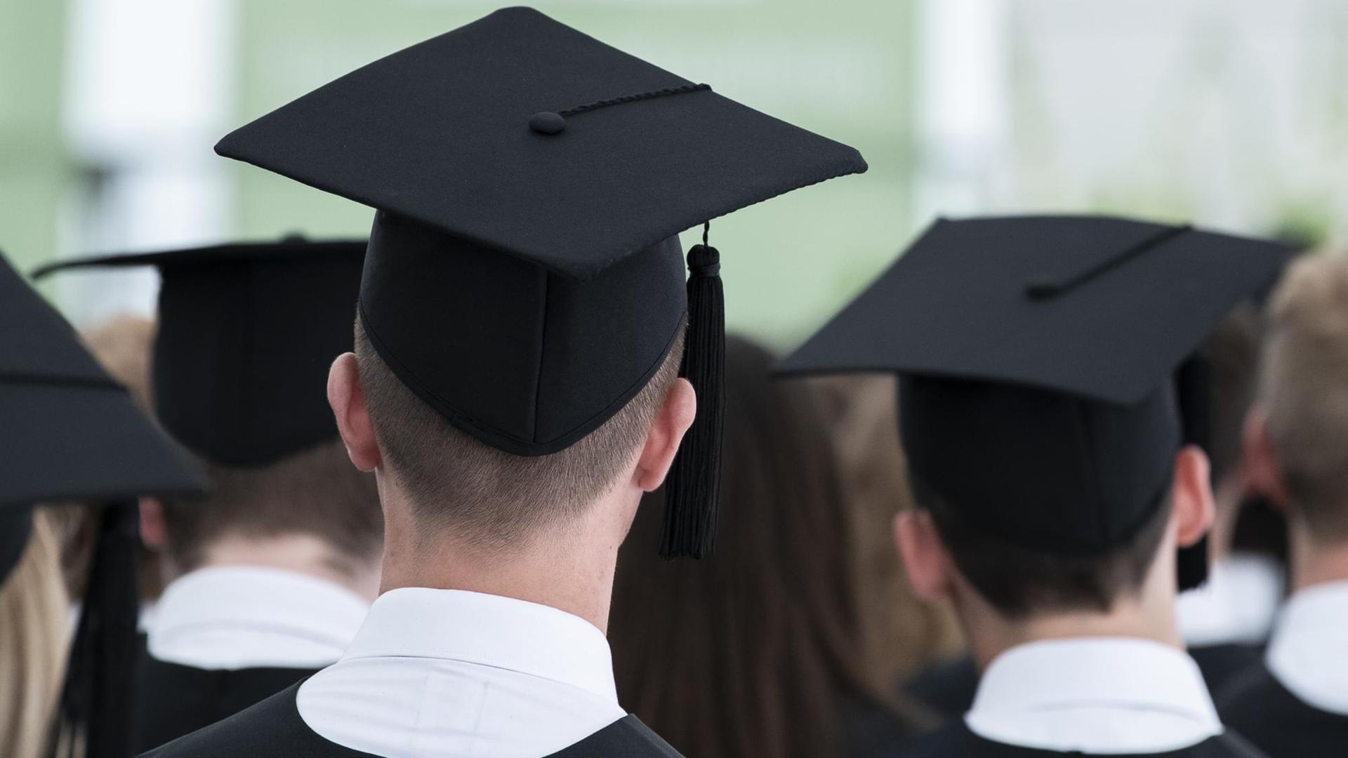 Absolventen sitzen während einer Master-Absolventenfeier in einem Zelt auf dem Gelände der Universität Mannheim. Absolventen sitzen während einer Master-Absolventenfeier in einem Zelt auf dem Gelände der Universität Mannheim.