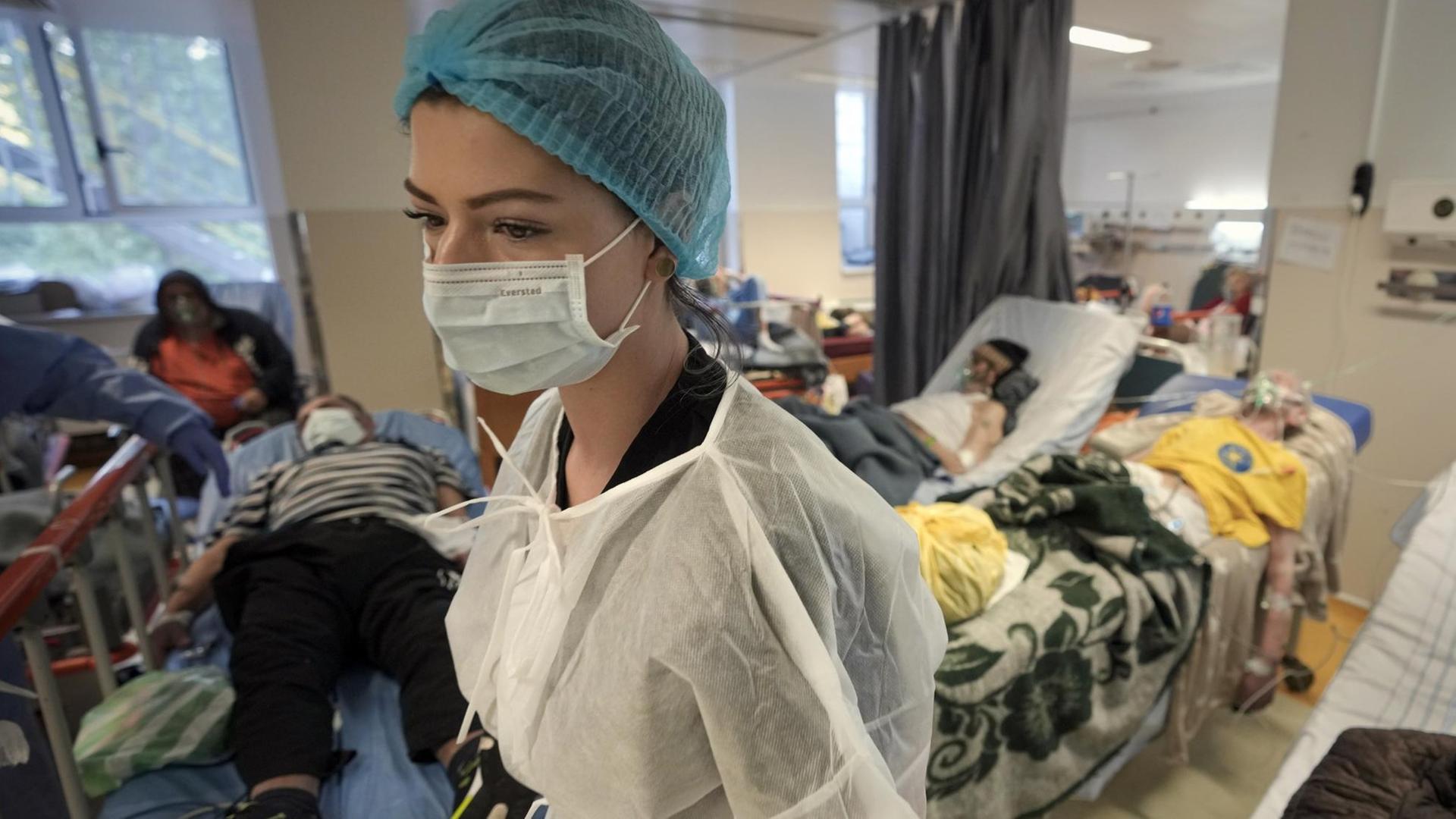 Ein Mitglied des medizinischen Personals geht durch einen überfüllten Corona-Isolationsraum im Universitäts-Notfallkrankenhaus im rumänischen Bukarest. Ein Mitglied des medizinischen Personals geht durch einen überfüllten Corona-Isolationsraum im Universitäts-Notfallkrankenhaus im rumänischen Bukarest.