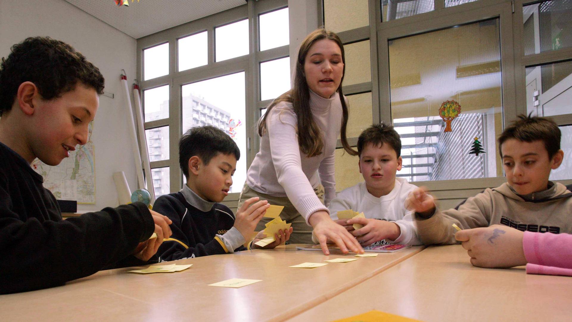 Eine Lehrerin unterrichtet Migrantenkinder in Deutsch Eine Lehrerin unterrichtet Migrantenkinder in Deutsch