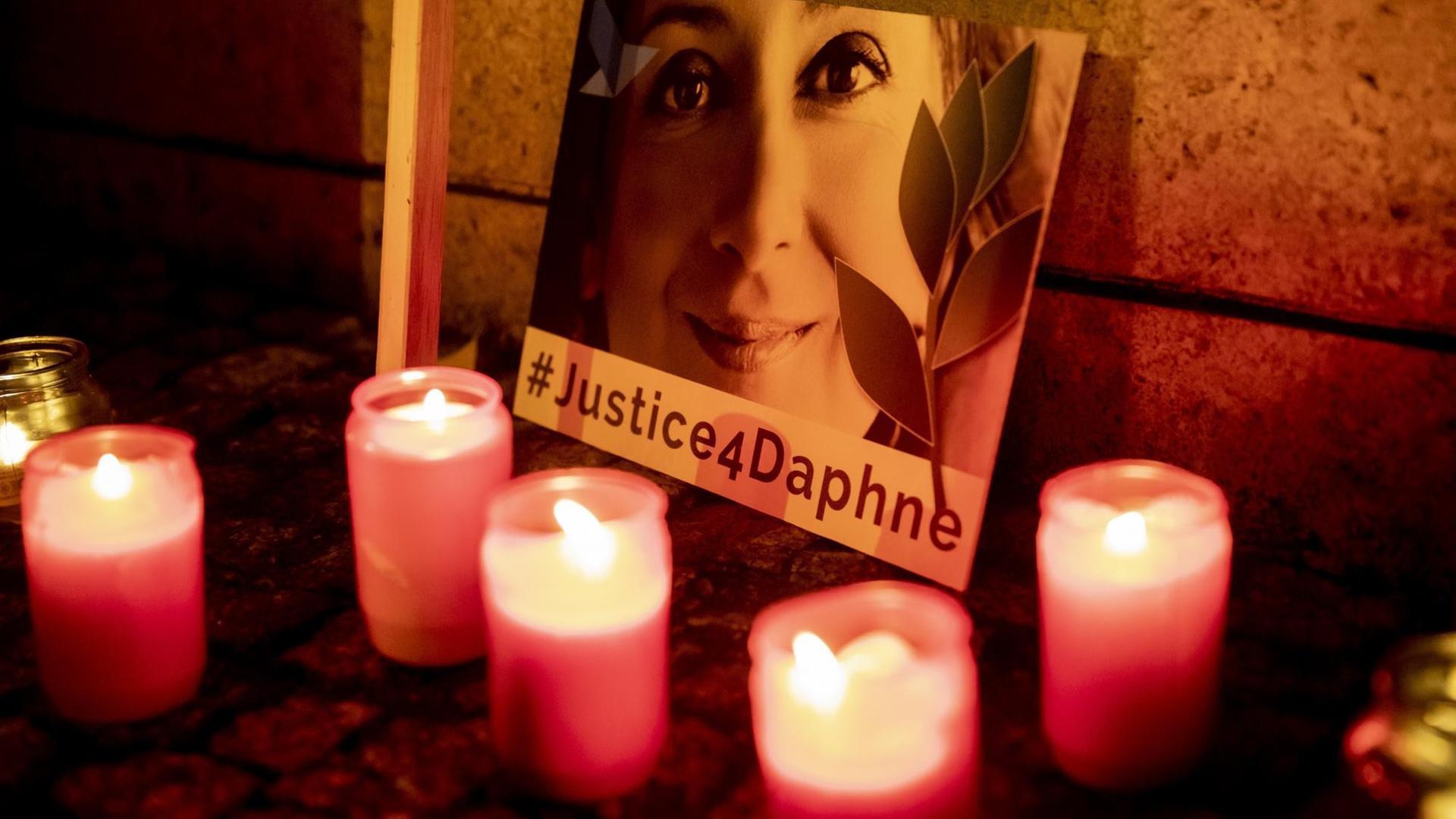 Mehrere Grabkerzen stehen vor einem Bild der maltesischen Investigativjournalistin Daphne Caruana Galizia. Darauf die Aufschrift: #Justice4Daphne. Mehrere Grabkerzen stehen vor einem Bild der maltesischen Investigativjournalistin Daphne Caruana Galizia. Darauf die Aufschrift: #Justice4Daphne.