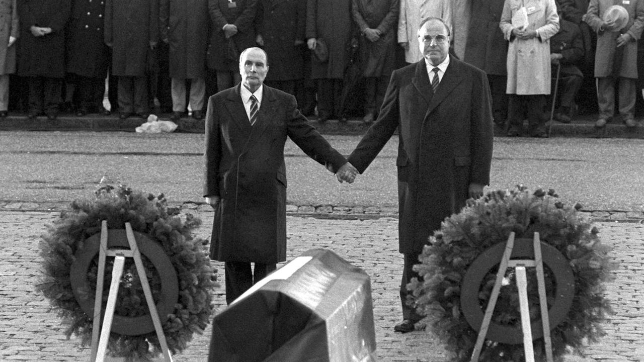  Historische Geste: Der französische Staatspräsident Francois Mitterrand (l) und Bundeskanzler Helmut Kohl reichen sich am 22.9.1984 über den Gräbern von Verdun die Hand. 