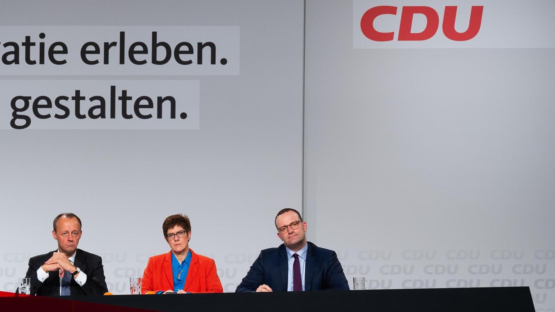 20.11.2018, Rheinland-Pfalz, Idar-Oberstein: Friedrich Merz (l-r), der frühere CDU/CSU-Fraktionschef, Annegret Kramp-Karrenbauer, CDU Generalsekretärin und Jens Spahn (CDU), Gesundheitsminister, sitzen bei der CDU-Regionalkonferenz auf dem Gelände der Messe Idar-Oberstein auf der Bühne. Zur zweiten Vorstellungsrunde der drei aussichtsreichsten Kandidaten für den CDU-Vorsitz sind rund 2000 CDU-Mitgliedern aus Rheinland-Pfalz und aus dem Saarland angereist. Foto: Silas Stein/dpa | Verwendung weltweit 20.11.2018, Rheinland-Pfalz, Idar-Oberstein: Friedrich Merz (l-r), der frühere CDU/CSU-Fraktionschef, Annegret Kramp-Karrenbauer, CDU Generalsekretärin und Jens Spahn (CDU), Gesundheitsminister, sitzen bei der CDU-Regionalkonferenz auf dem Gelände der Messe Idar-Oberstein auf der Bühne. Zur zweiten Vorstellungsrunde der drei aussichtsreichsten Kandidaten für den CDU-Vorsitz sind rund 2000 CDU-Mitgliedern aus Rheinland-Pfalz und aus dem Saarland angereist. Foto: Silas Stein/dpa | Verwendung weltweit