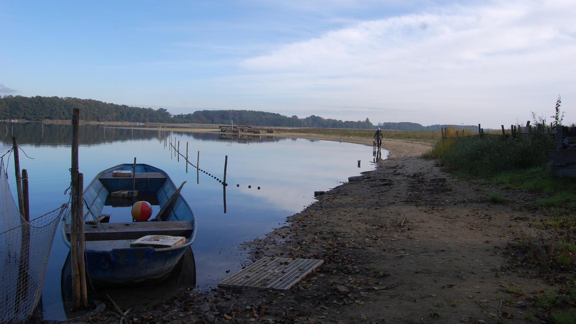 Der Seddiner See, im Vordergrund ein Boot, am Rand ein breiter, sandiger Uferstreifen Der Seddiner See, im Vordergrund ein Boot, am Rand ein breiter, sandiger Uferstreifen