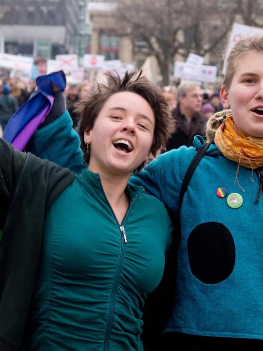 Zwei Befürworter der Aufwertung des Themas Homosexualität im Schulunterricht in Baden-Württemberg gehen am 01.02.2014 bei einer Demonstration in Stuttgart (Baden-Württemberg) über den Schlossplatz, in der Hand eine Regenbogenfahne.