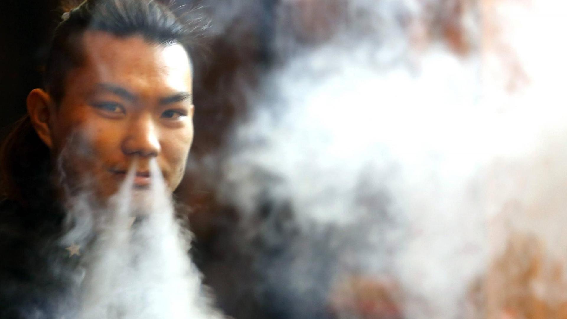 Das Bild zeigt einen rauchenden Mann in Peking.