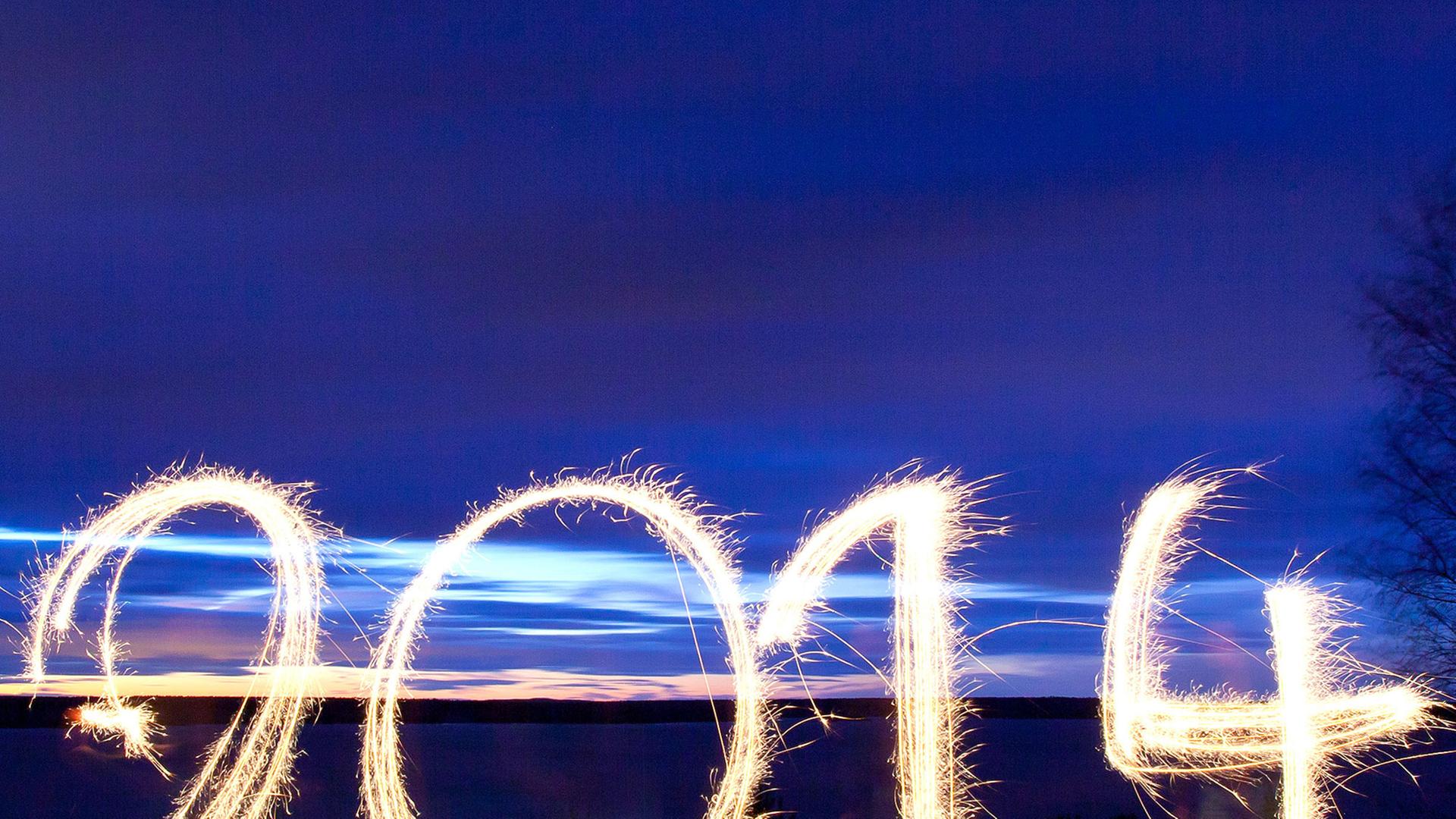 Mit Wunderkerzen steht "2014" in die abendliche Landschaft in der Lausitz geschrieben. Mit Wunderkerzen steht "2014" in die abendliche Landschaft in der Lausitz geschrieben.