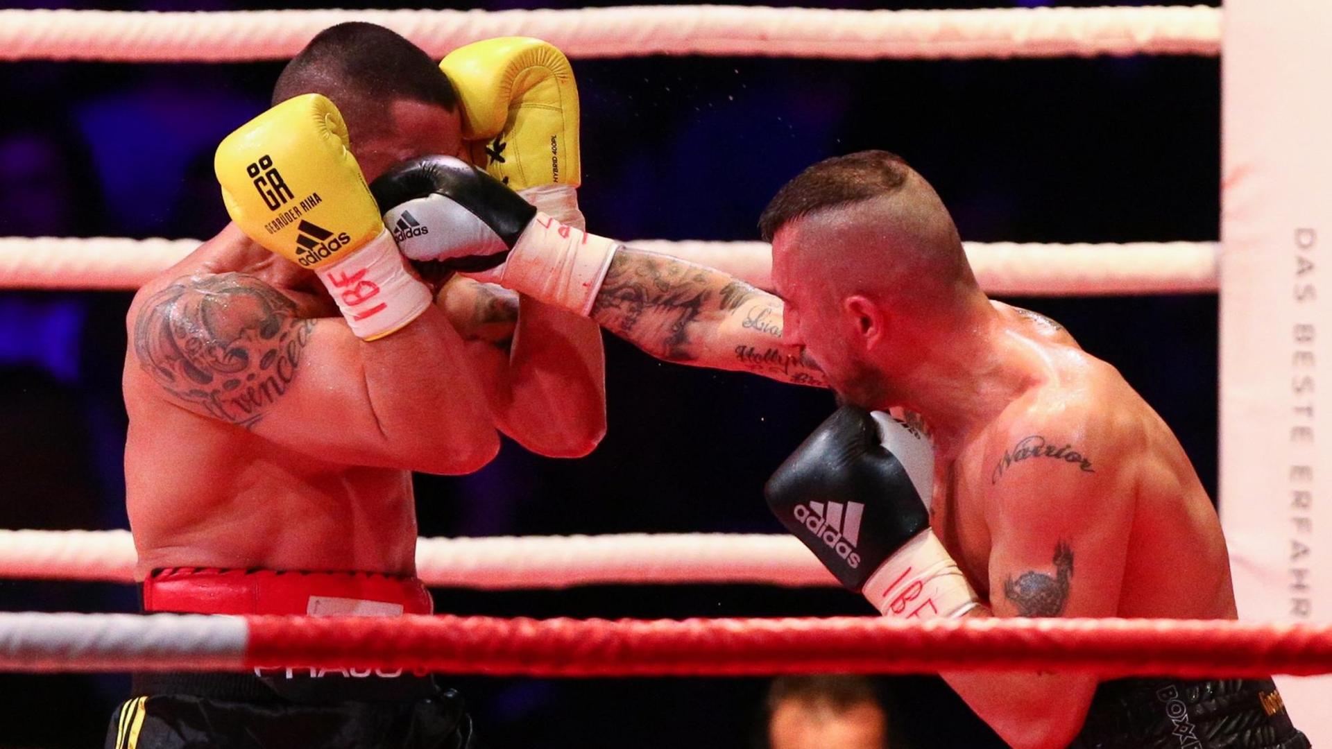 Boxkampf zwischen Marcos Nader und Gogi Knezevic in Wien. Ein Boxer schlägt den anderen mit einer rechten Gerade in die offene Deckung. Boxkampf zwischen Marcos Nader und Gogi Knezevic in Wien. Ein Boxer schlägt den anderen mit einer rechten Gerade in die offene Deckung.