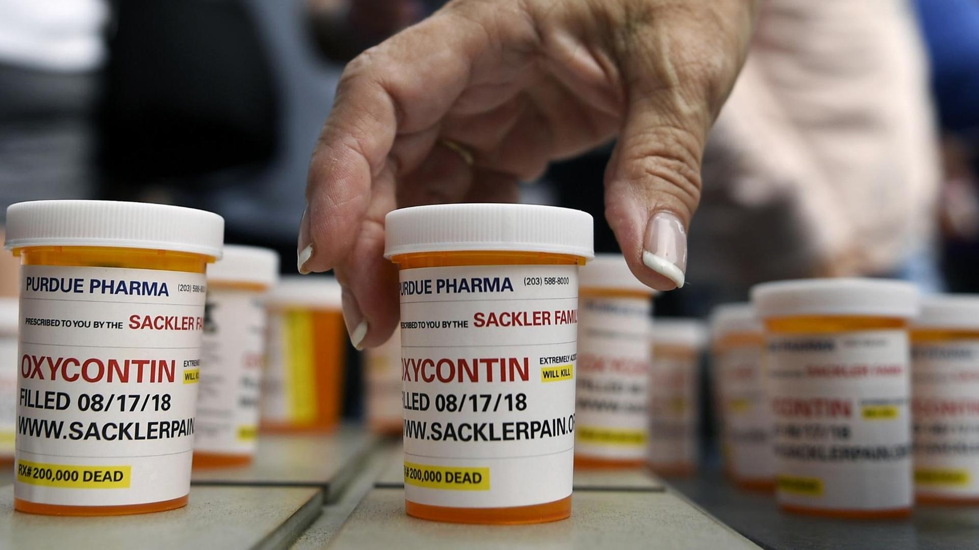 FILE - In this Aug. 17, 2018 file photo, family and friends who have lost loved ones to OxyContin and opioid overdoses leave pill bottles in protest outside the headquarters of Purdue Pharma, which is owned by the Sackler family, in Stamford, Conn. New York is suing the billionaire family behind Oxycontin, alleging the drugmaker fueled the opioid crisis by putting hunger for profits over patient safety. (AP Photo/Jessica Hill, File) | FILE - In this Aug. 17, 2018 file photo, family and friends who have lost loved ones to OxyContin and opioid overdoses leave pill bottles in protest outside the headquarters of Purdue Pharma, which is owned by the Sackler family, in Stamford, Conn. New York is suing the billionaire family behind Oxycontin, alleging the drugmaker fueled the opioid crisis by putting hunger for profits over patient safety. (AP Photo/Jessica Hill, File) |