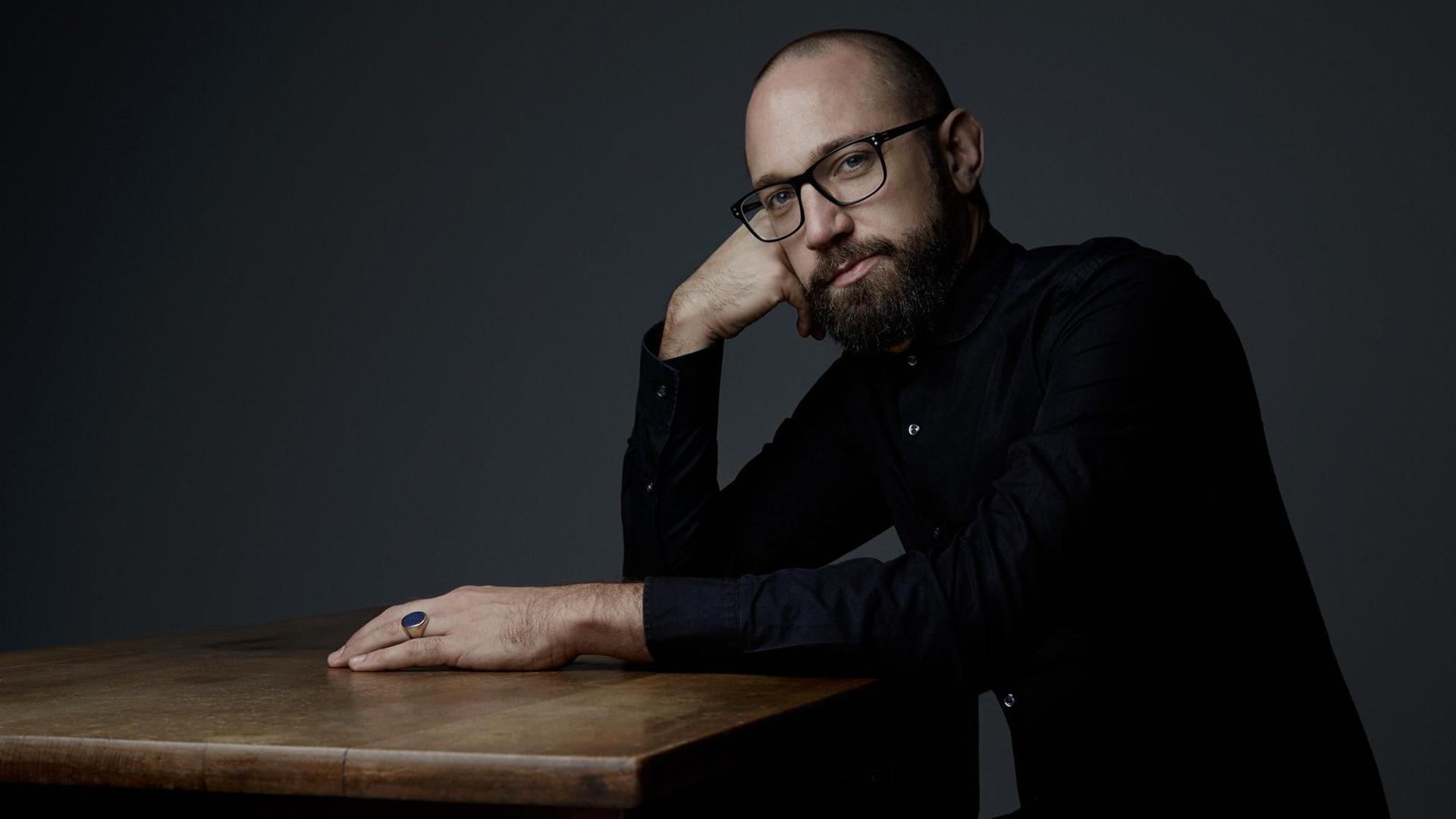 Der Musiker Lars Duppler sitzt an einem Tisch. Der Musiker Lars Duppler sitzt an einem Tisch.