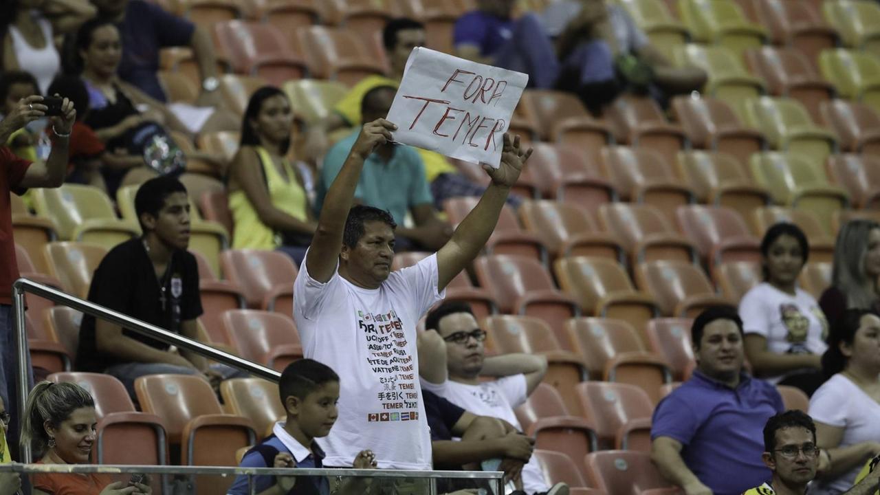 "Temer raus" steht - an den Übergangspräsidenten Michel Temer gerichtet - auf dem Plakat des Zuschauers beim Spiel Kolumbien gegen Japan in Manaus bei den Olympischen Sommerspielen.