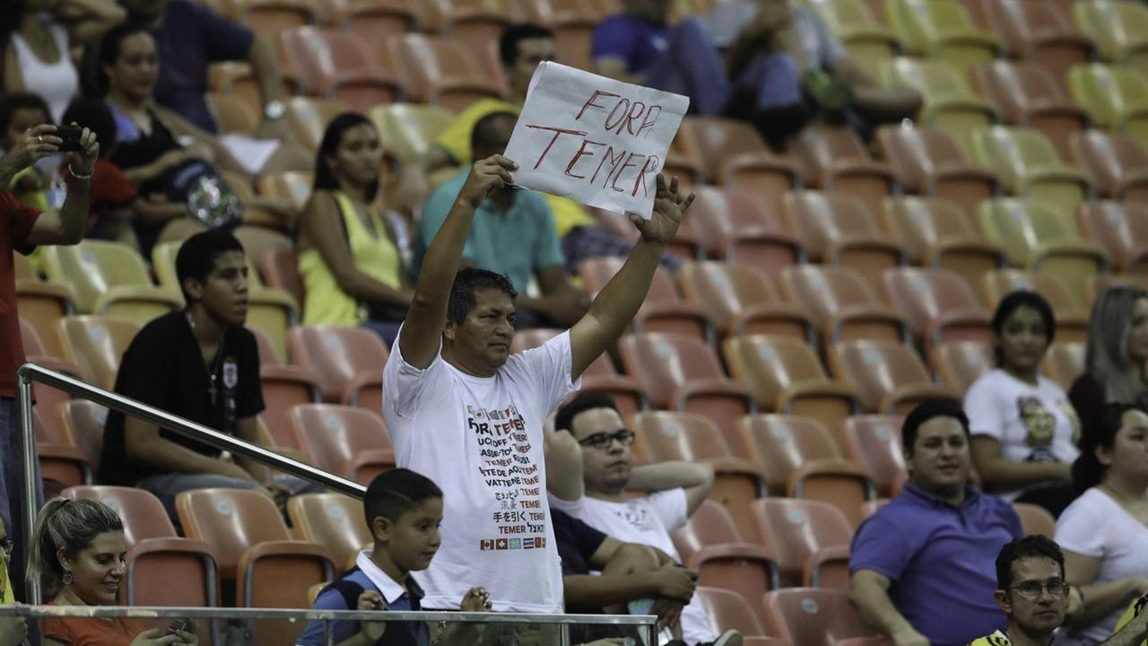 "Temer raus" steht - an den Übergangspräsidenten Michel Temer gerichtet - auf dem Plakat des Zuschauers beim Spiel Kolumbien gegen Japan in Manaus bei den Olympischen Sommerspielen. "Temer raus" steht - an den Übergangspräsidenten Michel Temer gerichtet - auf dem Plakat des Zuschauers beim Spiel Kolumbien gegen Japan in Manaus bei den Olympischen Sommerspielen.