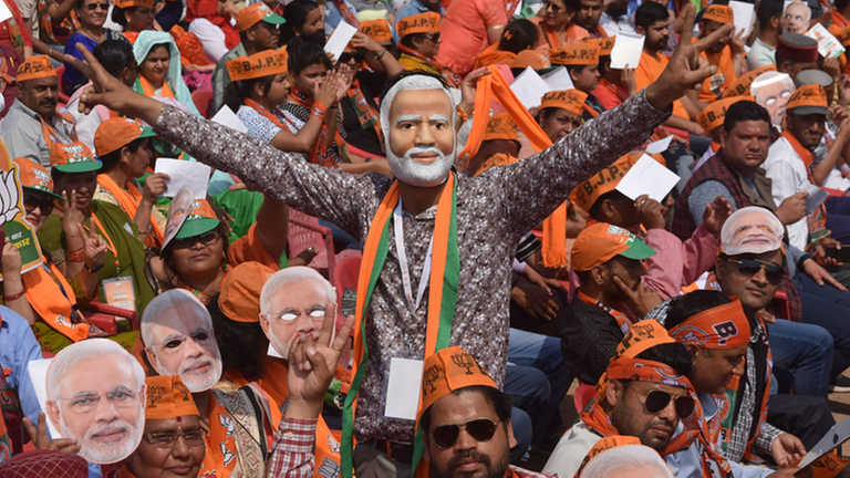 Inder tragen auf einer Demonstration Masken mit dem Bild von Indiens Premierminister Narendra Modi. Inder tragen auf einer Demonstration Masken mit dem Bild von Indiens Premierminister Narendra Modi.