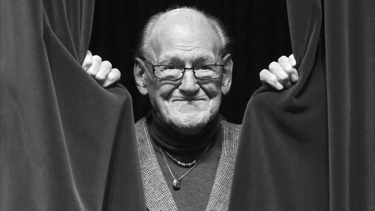 Ein Portrait-Foto von Herbert Köfer, er guckt durch einen Vorhang.