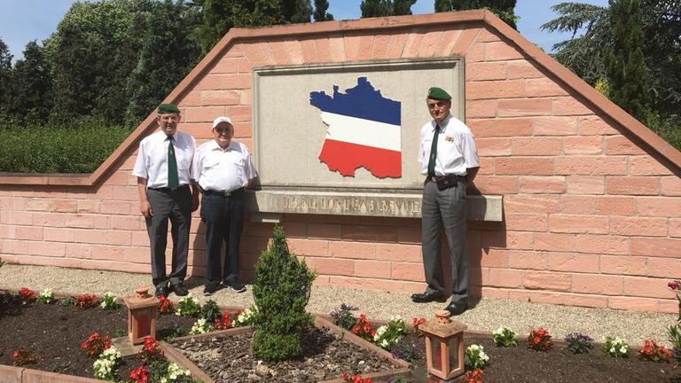 Drei Veteranen der Fremdenlegion stehen vor einer französischen Gedenkstätte für gefallene Soldaten des Zweiten Weltkrieges Drei Veteranen der Fremdenlegion stehen vor einer französischen Gedenkstätte für gefallene Soldaten des Zweiten Weltkrieges