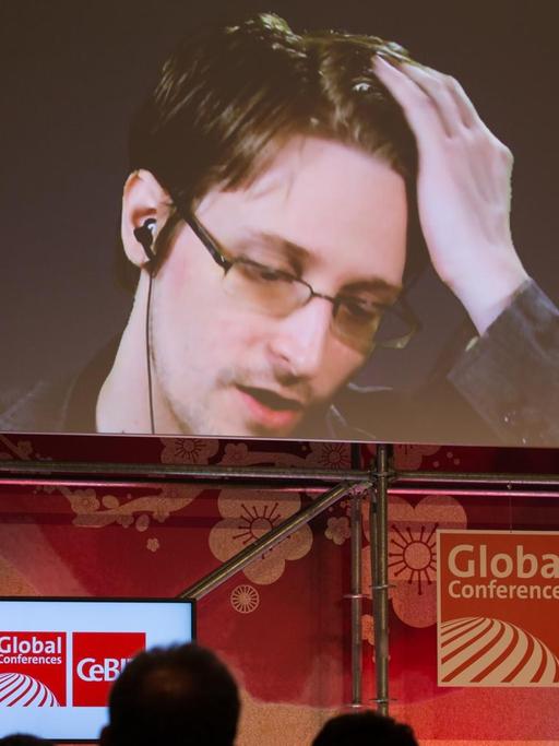 Der US-amerikanische Whistleblower und ehemalige CIA-Mitarbeiter Edward Snowden spricht am 21.03.2017 bei der IT-Messe CeBIT in Hannover (Niedersachsen) auf einer Videowand. Die IT-Messe CeBIT will ihr Fachpublikum mit konkreten Anwendungsbeispielen für neue Technologien überzeugen. Zu der fünftägigen Veranstaltung (20.-24. März) mit über 3000 Ausstellern aus 70 Ländern werden rund 200000 Besucher erwartet. Partnerland ist Japan.