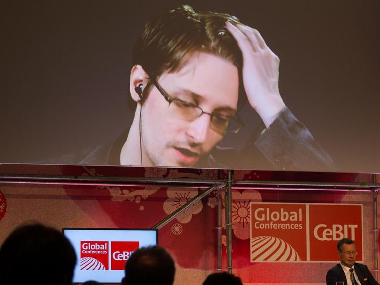 Der US-amerikanische Whistleblower und ehemalige CIA-Mitarbeiter Edward Snowden spricht am 21.03.2017 bei der IT-Messe CeBIT in Hannover (Niedersachsen) auf einer Videowand. Die IT-Messe CeBIT will ihr Fachpublikum mit konkreten Anwendungsbeispielen für neue Technologien überzeugen. Zu der fünftägigen Veranstaltung (20.-24. März) mit über 3000 Ausstellern aus 70 Ländern werden rund 200000 Besucher erwartet. Partnerland ist Japan.