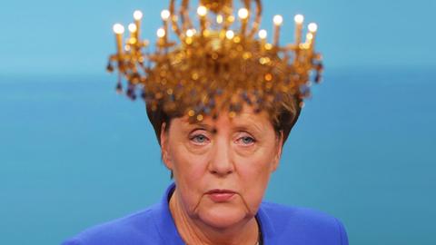 Ein Kronenleuchter hängt am 03.09.2017 in Berlin in den Fernsehstudios in Adlershof beim TV-Duell von Bundeskanzlerin Merkel (CDU) und Herausforderer Martin Schulz (SPD) , wobei Merkel auf einem Bildschirm zu sehen ist.