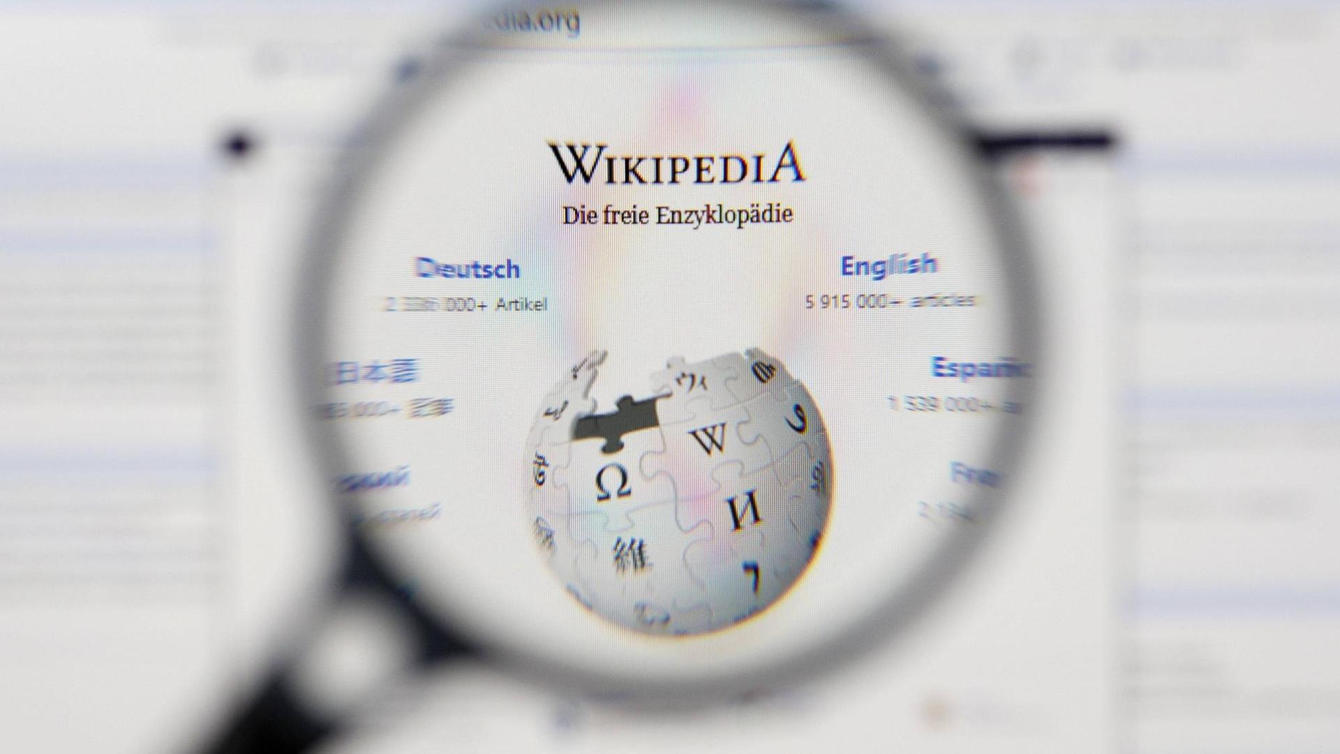 Das Logo von Wikipedia - durch eine Lupe vergrößert. 