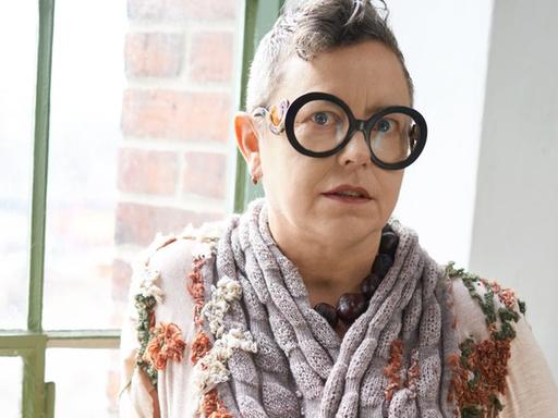 Porträt der Modedesignerin Martina Glomb. Sie trägt eine modische Brille und einen Kurzhaarschnitt.