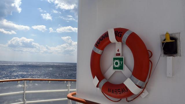 Ein Rettungsring mit Signalboje hängt auf einem Deck des Kreuzfahrtschiffs MS Hamburg. 