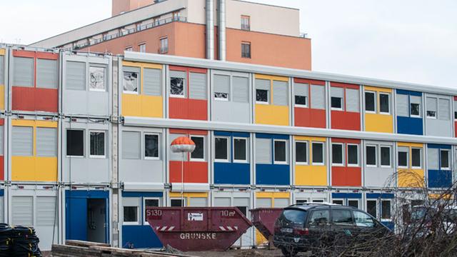 Dreifach übereinandergestapelt stehen bunte Wohncontainer im Berliner Bezirk Treptow-Köpenick.