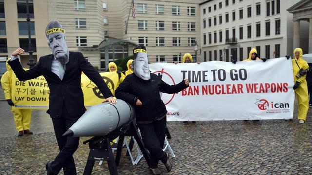 Aktivisten der Internationalen Kampagne zur Abschaffung von Atomwaffen (ICAN) protestieren vor der amerikanischen Botschaft in Berlin mit Masken des nordkoreanischen Machthabers Jong-un (r) und des US-Präsidenten Trump gegen den Konflikt zwischen Nordkorea und den USA.