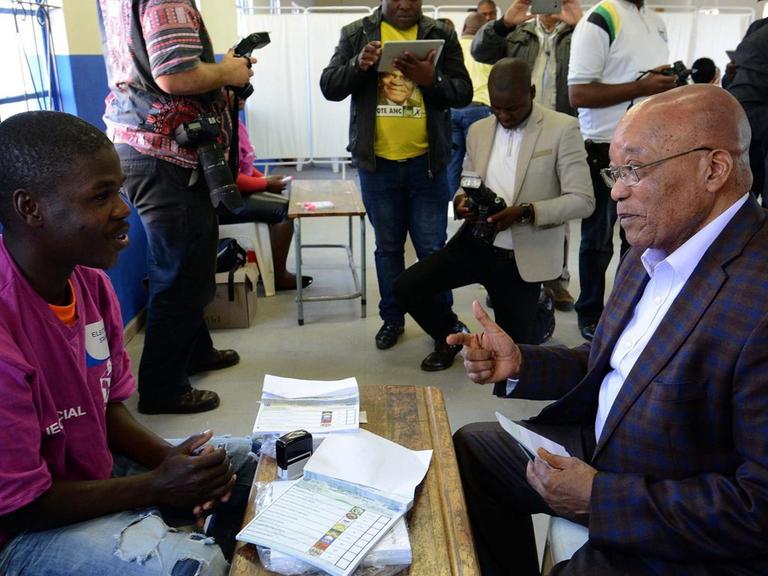 Präsident Jacob Zuma spricht mit einem Helfer in einem Wahllokal in Nkandla.
