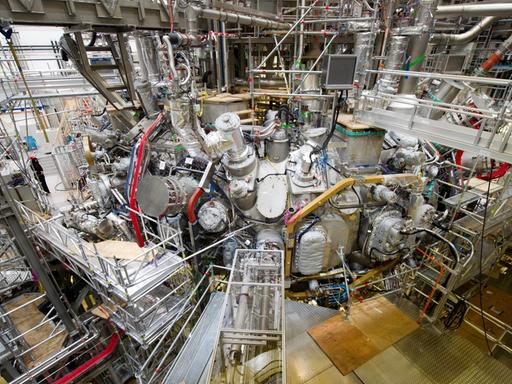 In der Kernfusionsforschungsanlage "Wendelstein 7-X" in Greifswald (Mecklenburg-Vorpommern) ist am 10.12.2015 das erste Plasma erzeugt worden. Das Bild zeigt ein großes Gebilde aus Metall in einer Halle.
