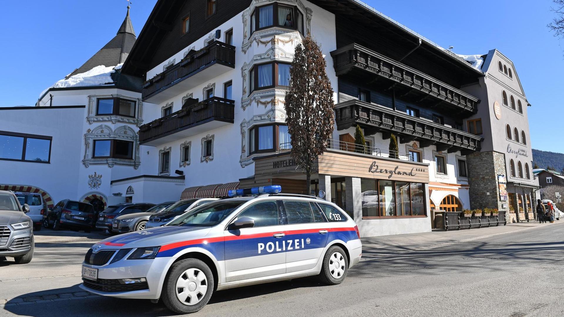 Ein Polizei-Auto fährt an einem Ski-Hotel vorbei Ein Polizei-Auto fährt an einem Ski-Hotel vorbei