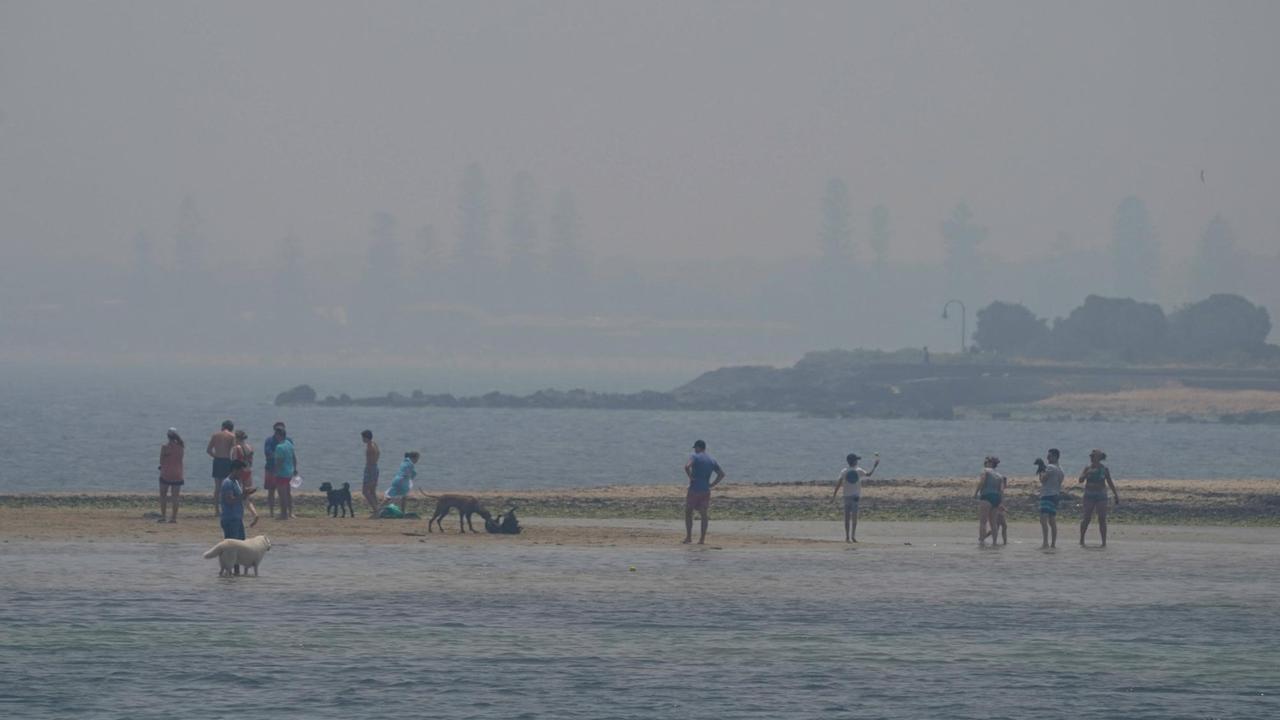 Der Rauch der australischen Buschfeuer ist weithin sichtbar - Menschen am Brighton Beach in Melbourne