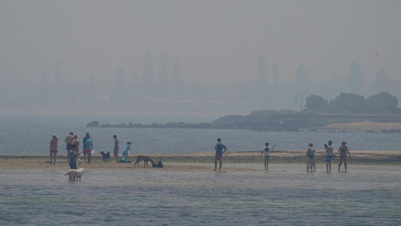 Der Rauch der australischen Buschfeuer ist weithin sichtbar - Menschen am Brighton Beach in Melbourne Der Rauch der australischen Buschfeuer ist weithin sichtbar - Menschen am Brighton Beach in Melbourne