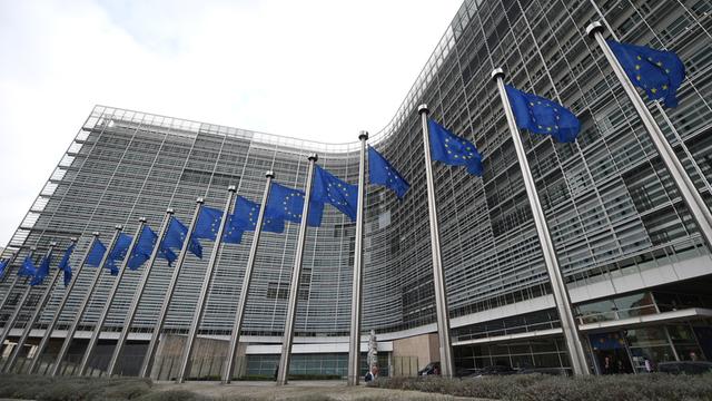Vor dem Gebäude der EU-Kommission wehen mehrere blaue EU-Fahnen.