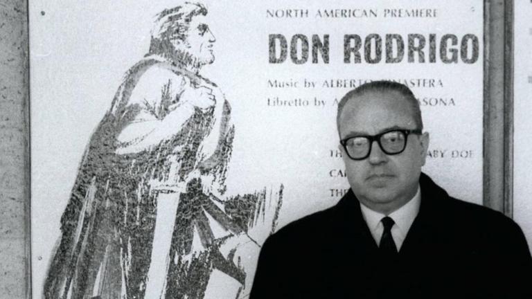 Am 21.12.1976 steht Alberto Ginastera in einem dunklen Mantel vor einem Plakat, das seine Oper "Don Rodrigo" ankündigt. Am 21.12.1976 steht Alberto Ginastera in einem dunklen Mantel vor einem Plakat, das seine Oper "Don Rodrigo" ankündigt.
