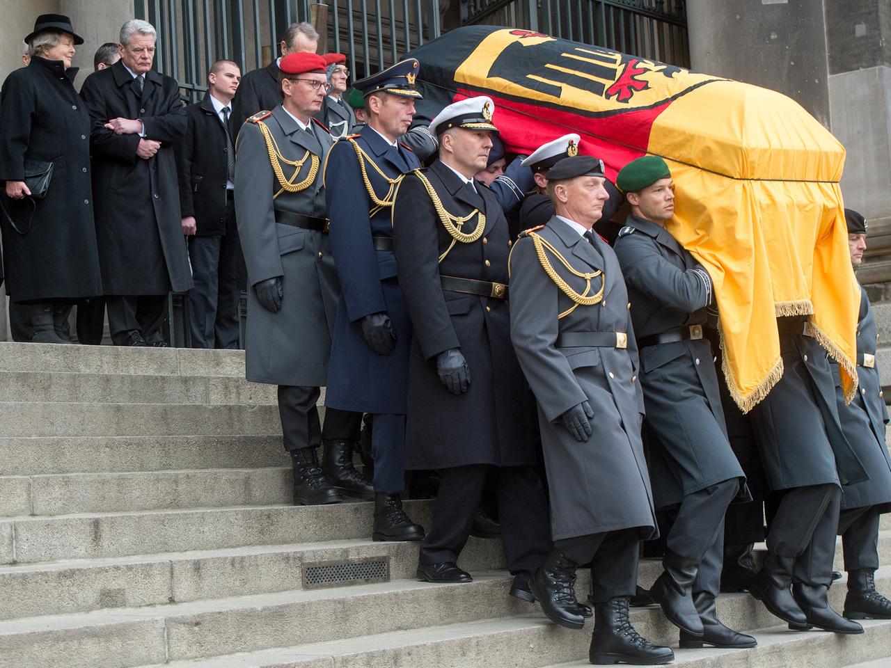 Soldaten tragen den mit einer Deutschlandflagge bedeckten Sarg die Stufen des Berliner Doms hinunter, dahinter gehen Marianne von Weizsäcker und Joachim Gauck. Soldaten tragen den mit einer Deutschlandflagge bedeckten Sarg die Stufen des Berliner Doms hinunter, dahinter gehen Marianne von Weizsäcker und Joachim Gauck.