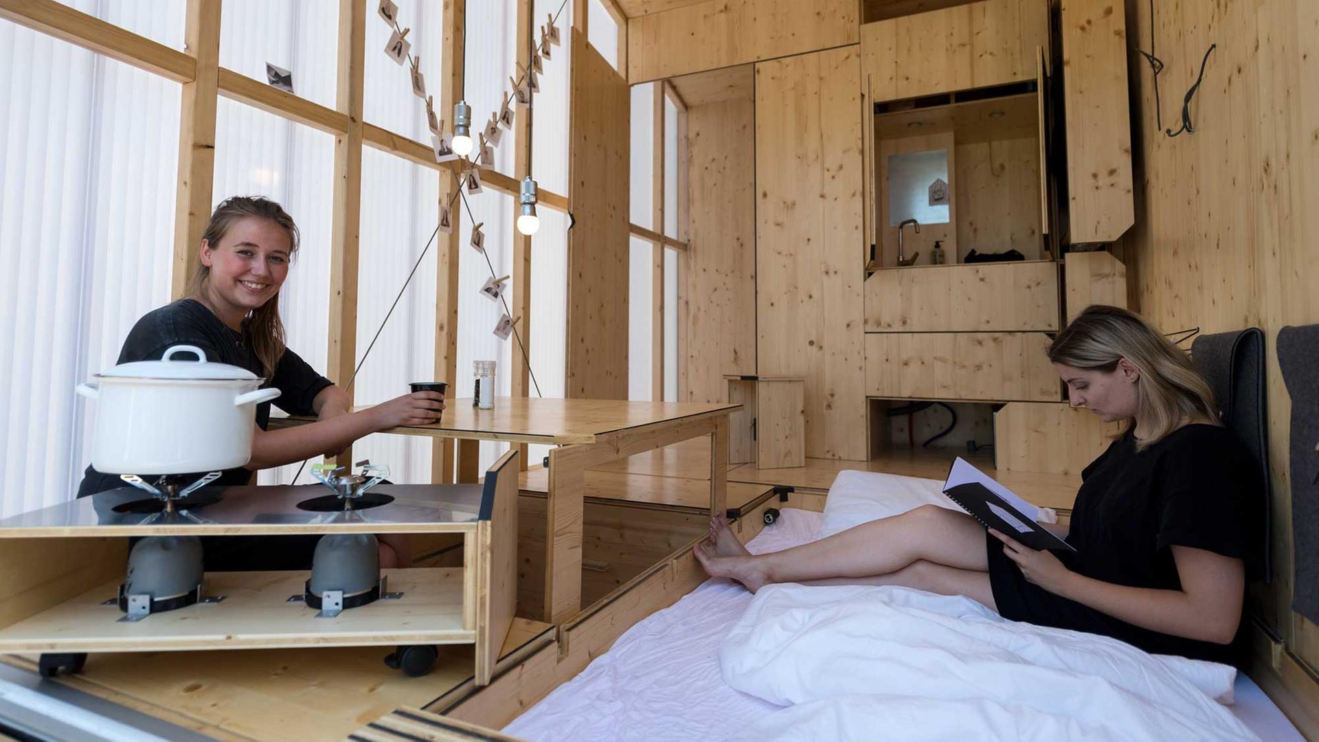 Architekturstudentinnen Sarah Ullmayer (r) und Sophie Kany sitzen am 20.07.2017 im Bauhaus Campus in Berlin in dem von ihnen entworfenen Tiny Haus (Minihaus) "35KubikHeimat".