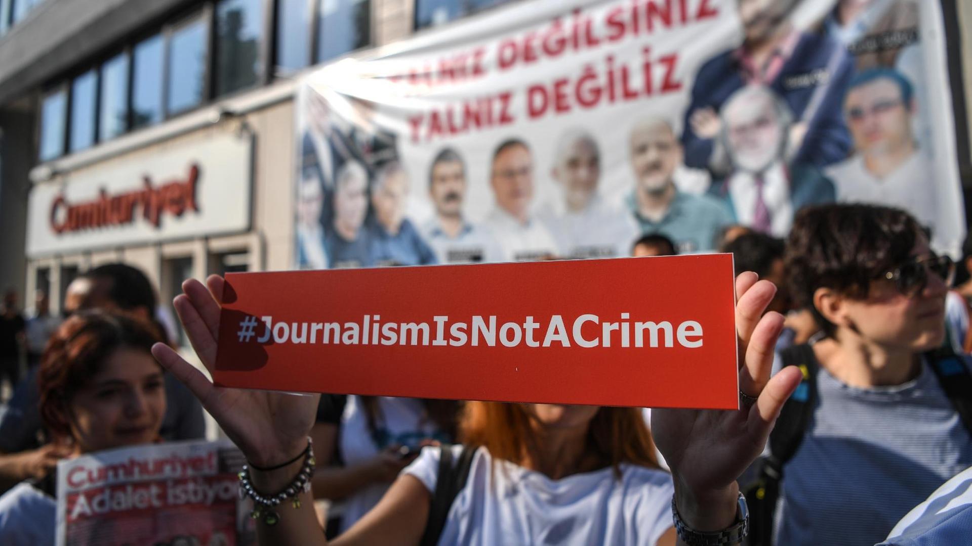 Vor der Zentrale der "Cumhuriyet" in Istanbul protestieren Menschen gegen den Prozess gegen Mitarbeiter der Zeitung. Vor der Zentrale der "Cumhuriyet" in Istanbul protestieren Menschen gegen den Prozess gegen Mitarbeiter der Zeitung.