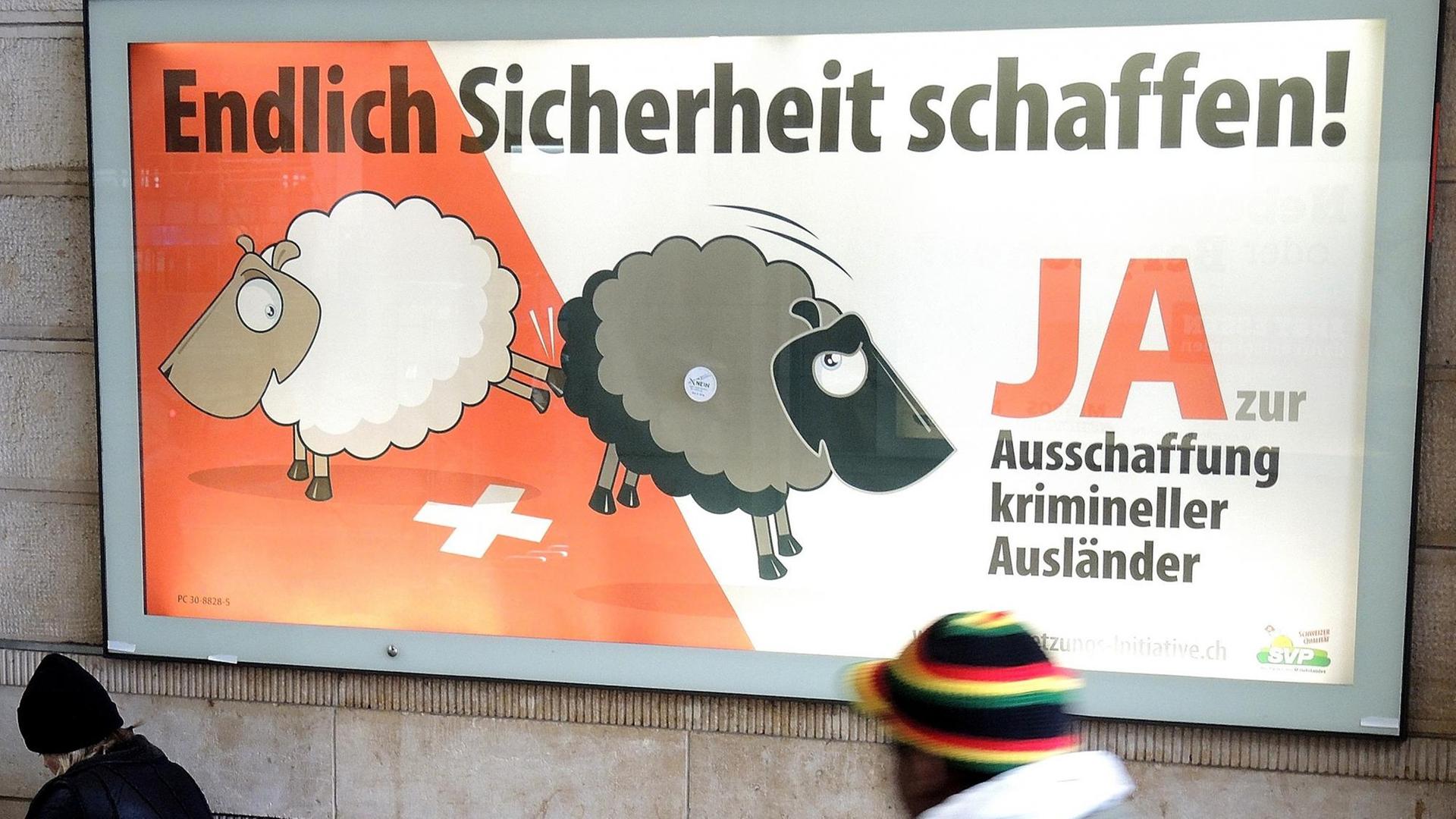 Ein Mann geht am Hauptbahnhof von Basel an einem Plakat der Schweizerischen Volkspartei (SVP) vorbei, auf dem die Ausweisung (Ausschaffung) krimineller Ausländer gefordert wird.