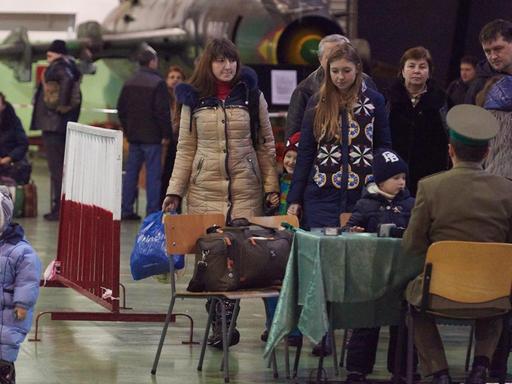 Eine Familie aus der Ukraine kommt in einem Militärflughafen in Polen an.