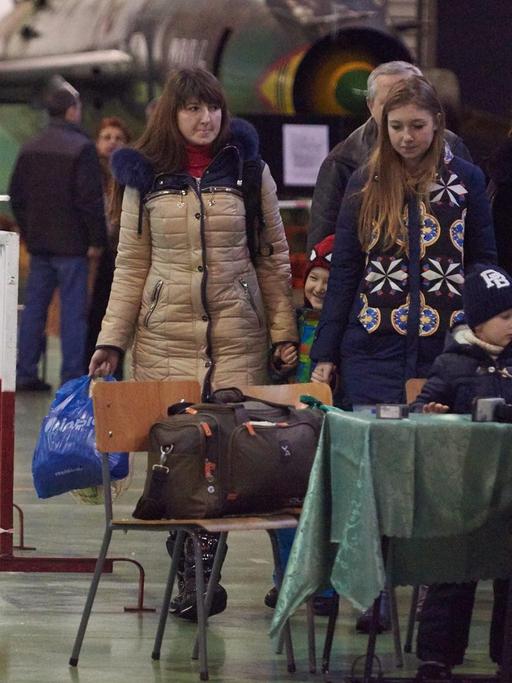 Eine Familie aus der Ukraine kommt in einem Militärflughafen in Polen an.