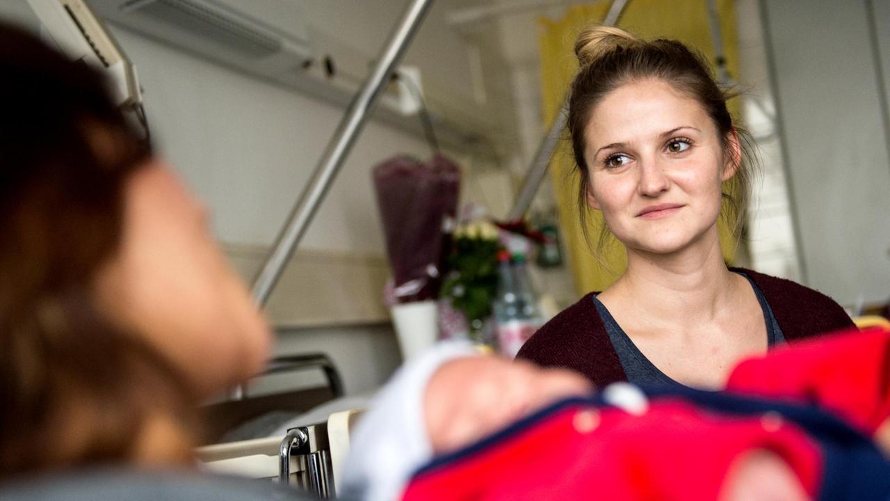 Babylotsin Anne Mellinger (r) unterhält sich am 10.12.2015 im Klinikum Frankfurt Höchst in Frankfurt am Main mit einer Mutter. Babylotsin Anne Mellinger (r) unterhält sich am 10.12.2015 im Klinikum Frankfurt Höchst in Frankfurt am Main mit einer Mutter.