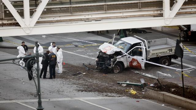Polizisten untersuchen am 31.10.2017 in New York (USA) auf der Straße einen stark beschädigten PKW.