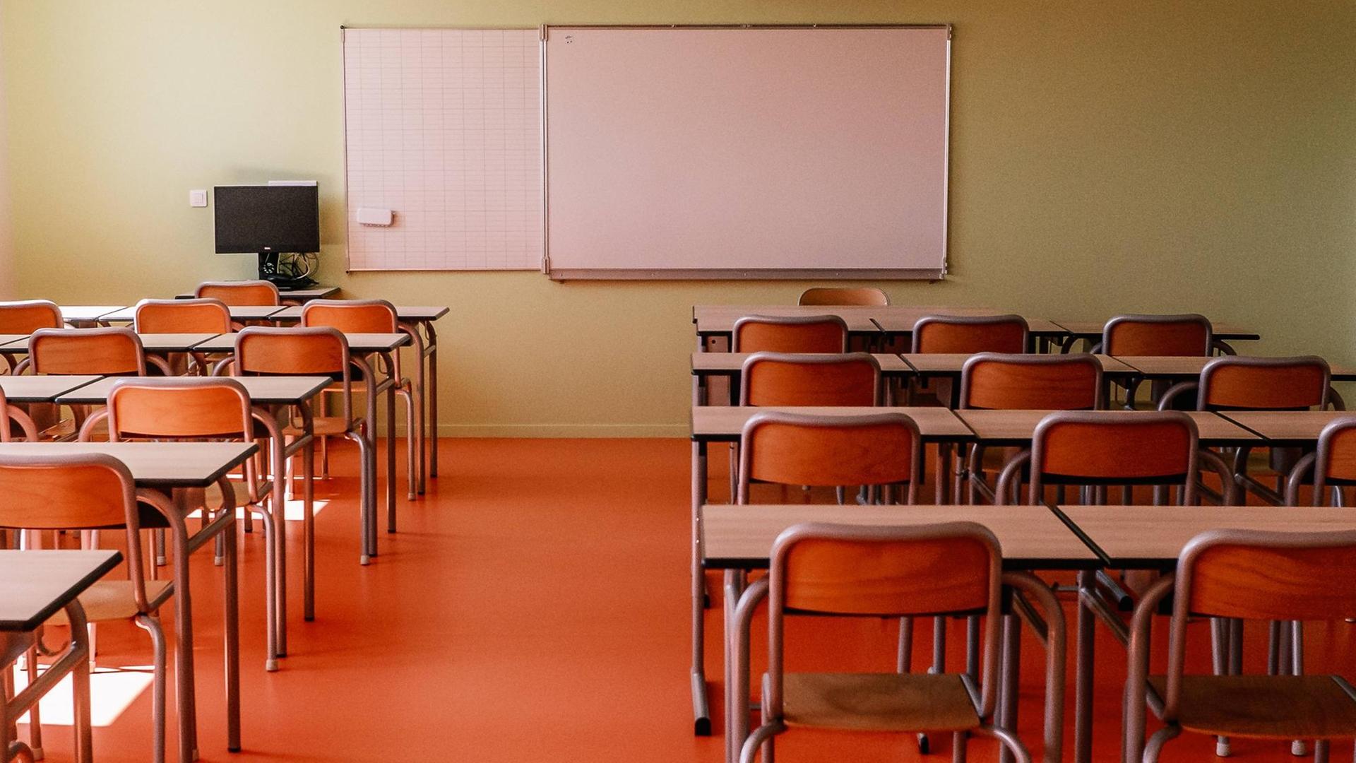 Ein leeres Klassenzimmer mit Blick Richtung Whiteboard.