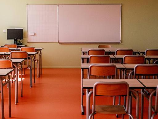 Ein leeres Klassenzimmer mit Blick Richtung Whiteboard.
