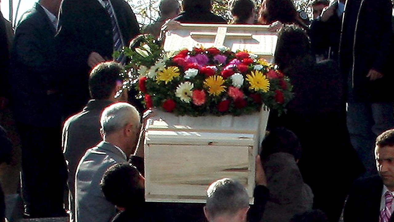 Männer tragen einen Sarg auf einem türkischen Friedhof. Männer tragen einen Sarg auf einem türkischen Friedhof.